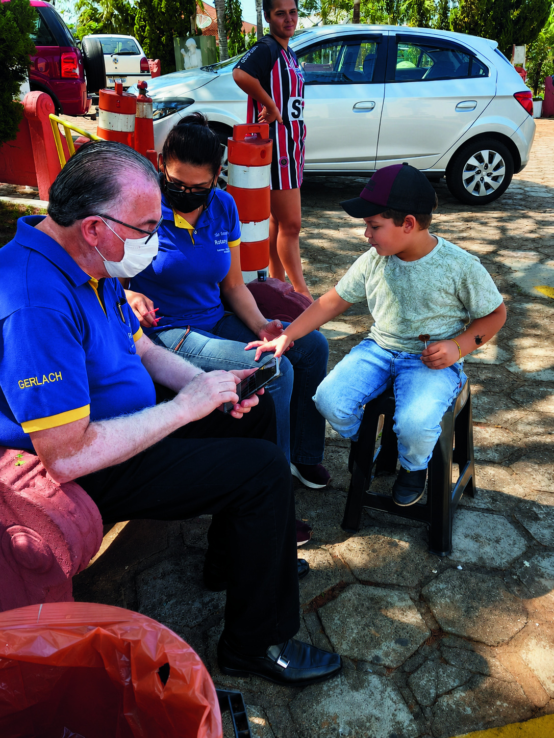 Rotarianos em ação comunitária com crianças