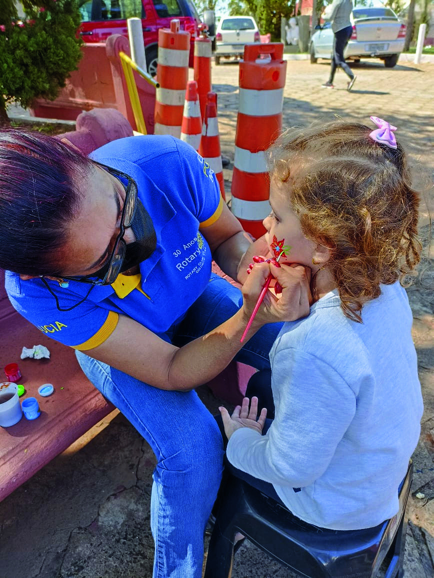 Voluntária do Rotary em atendimento a criança